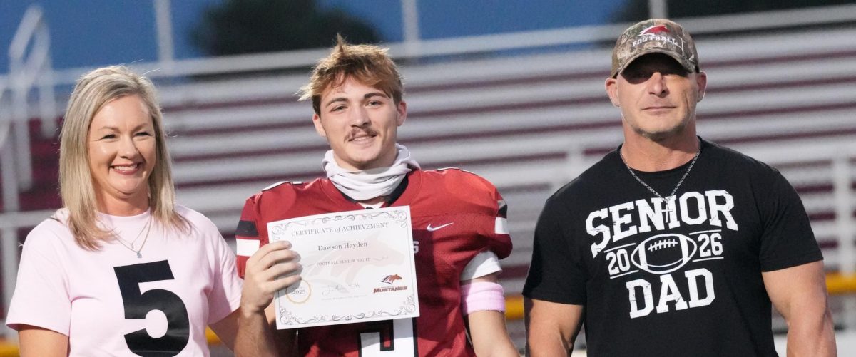 Number 5, Dawson Hayden, with his family  holding his certificate during the senior appreciation on October 17 before the Mccracken Vs. Christian county game. After all of the seniors got their certificate they all held hand and walked across the field. 