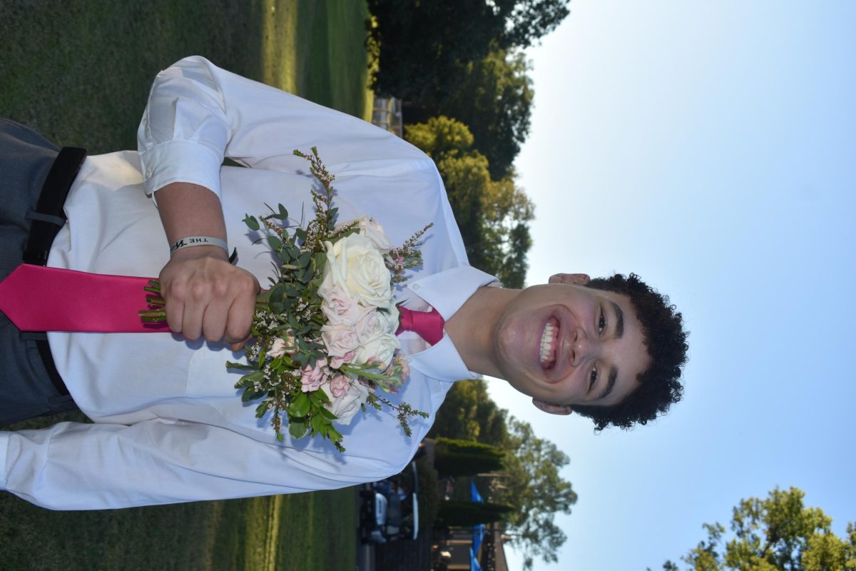 Senior Jack Nelson smiles with his dates flower bouquet during homecoming festivities. 