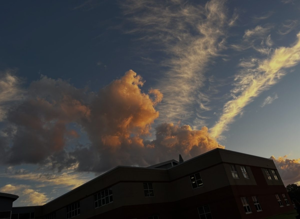 Lily Hegg taking a photo of the clouds in the MCHS bus circle on October 2nd, because they look pretty. Lily loves taking photos of the sky, and on that day it seemed to grab her attention. 