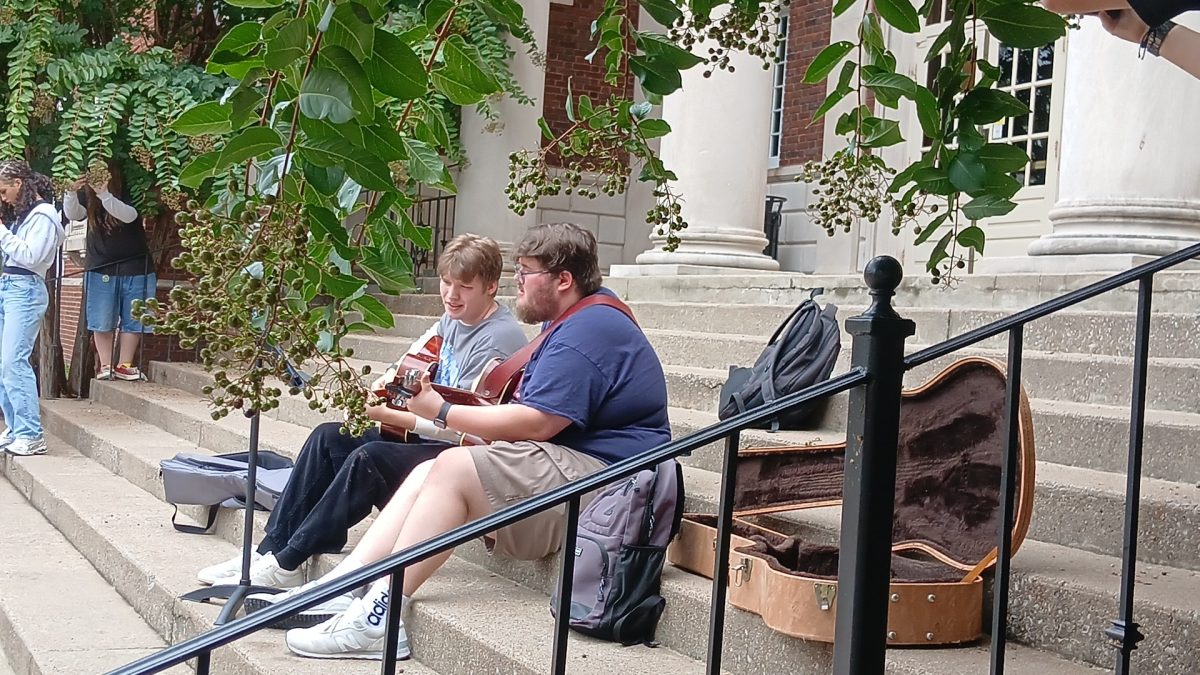 Two students preforming on dorm steps at Murray State