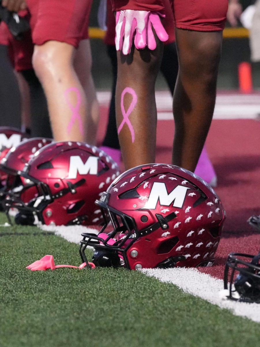 October 17, 2025 Mccracken Vs. Christian County football game. Players line up with their helmets placed in from of them. They are waiting for the seniors to get done with their walk. 
