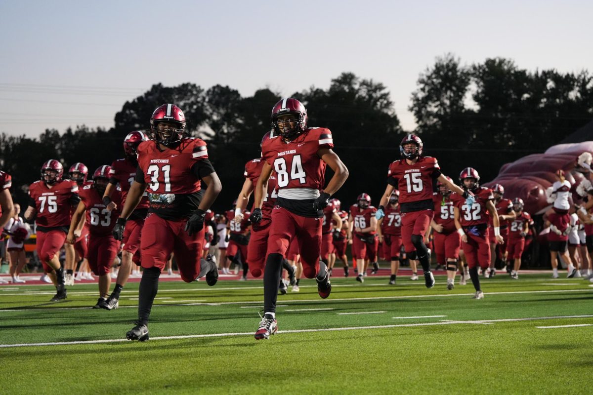 The football team running out to start off the Mustang Vs. Murray.