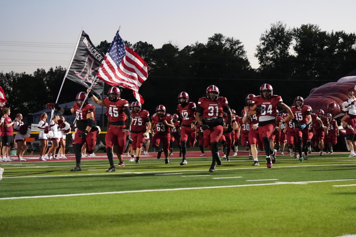 The football team running out to start off the Mustang Vs. Murray.