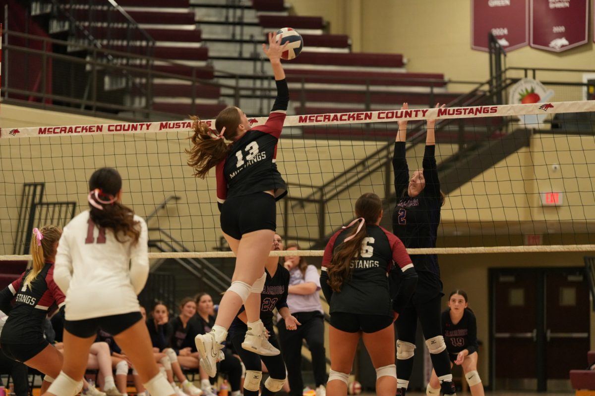 Reagan Hill (12) spikes a volleyball over the net. She was one of many senior girls that were celebrated during volleyball's Senior Night. The varsity team won both of their games that night. 