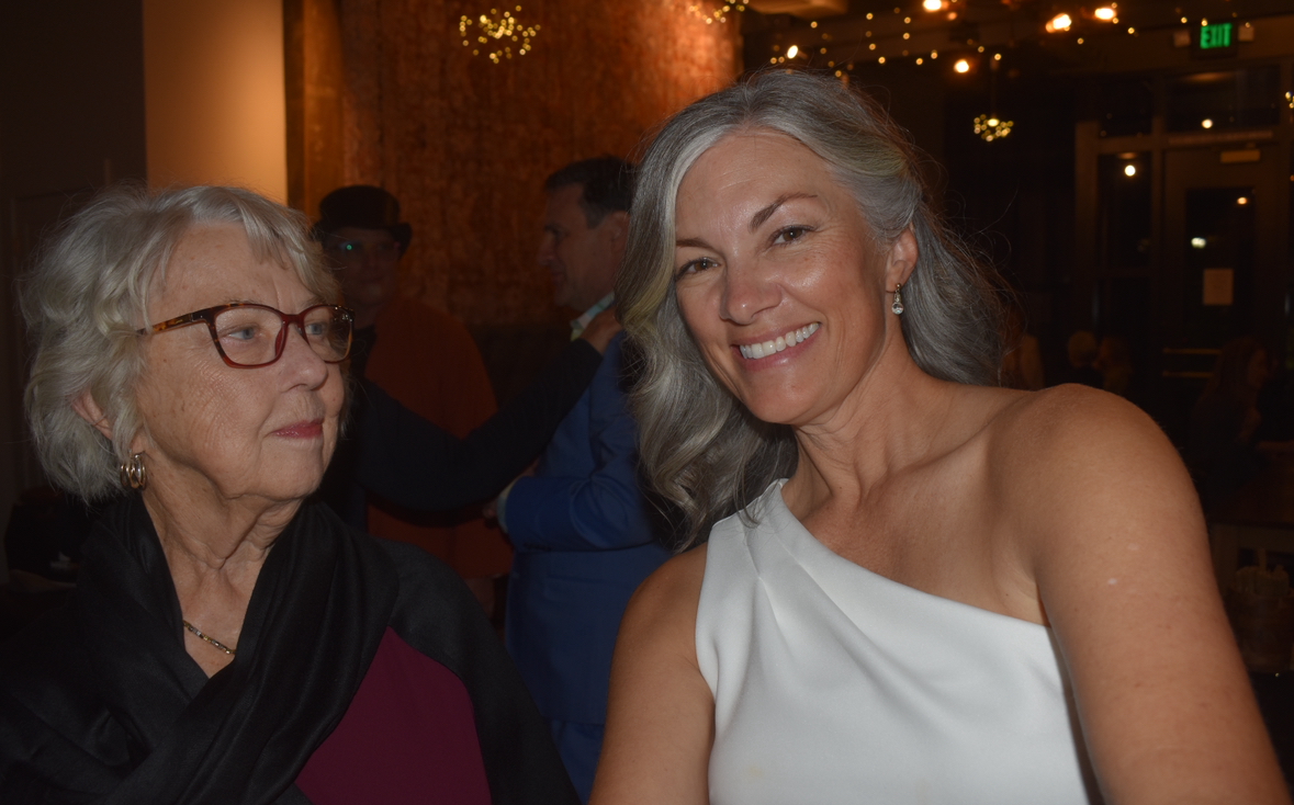 My mom, Emily Ricketts, smiling for the camera as my Nana, Linda Wood, looks at her. This was towards the end of my moms wedding reception. "I am very happy for her and glad I got to see my family", Emily Ricketts stated.  