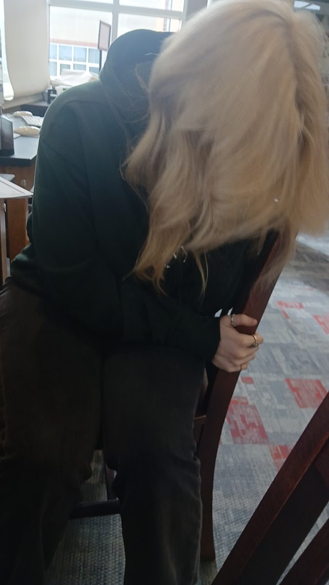Kayla Mamon, a senior at MCHS laughing in a library chair while working on a class assignment with Katelyn. The two had been doing assignments together when they got off track. When seeing her photo Kayla comments "oh my gosh."