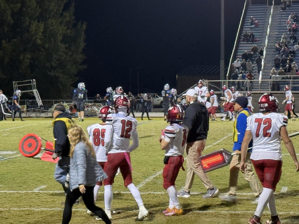 Teams set up for play. Other photographers along with players and head coach Tyler Brooks. This game was played at Buckley stadium in Graves county on 10/31